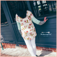 Woman wearing a spring mint color block top showing the back which is ivory with peach and rose color florals with green foliage. The-Brown-Eyed-Girl -Products
