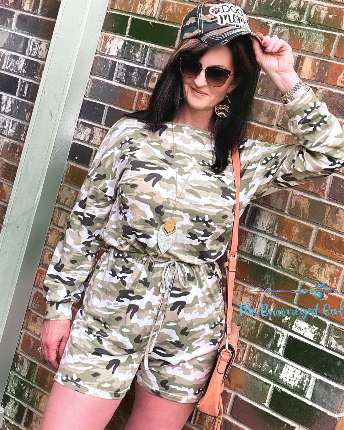 Woman wearing a olive and grey camo long sleeve romper. It's figure flattering with a cinched waist fits true to size. Material is very comfortable can be worn on or off the shoulder. The-Brown-eyed-Girl-Boutique 